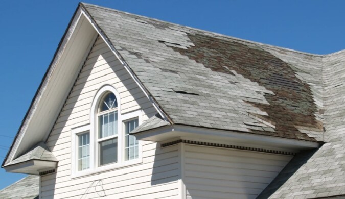 A section of the roof shows significant shingle deterioration