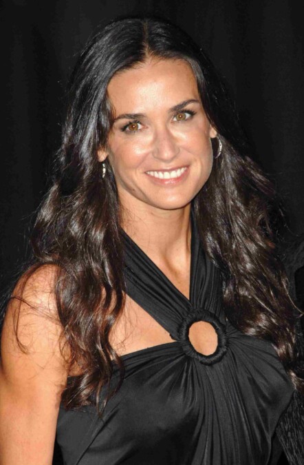 Woman smiling at a formal event in an elegant black dress
