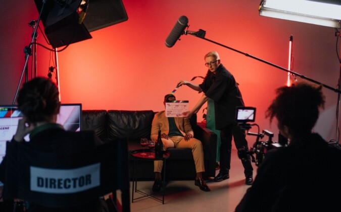 Film crew arranging lighting and equipment on an indoor set
