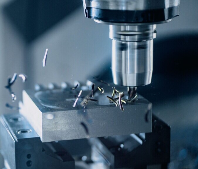 CNC milling machine precisely cutting a metal component for a screen prop